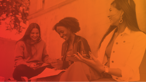 Three women laughing looking at phones